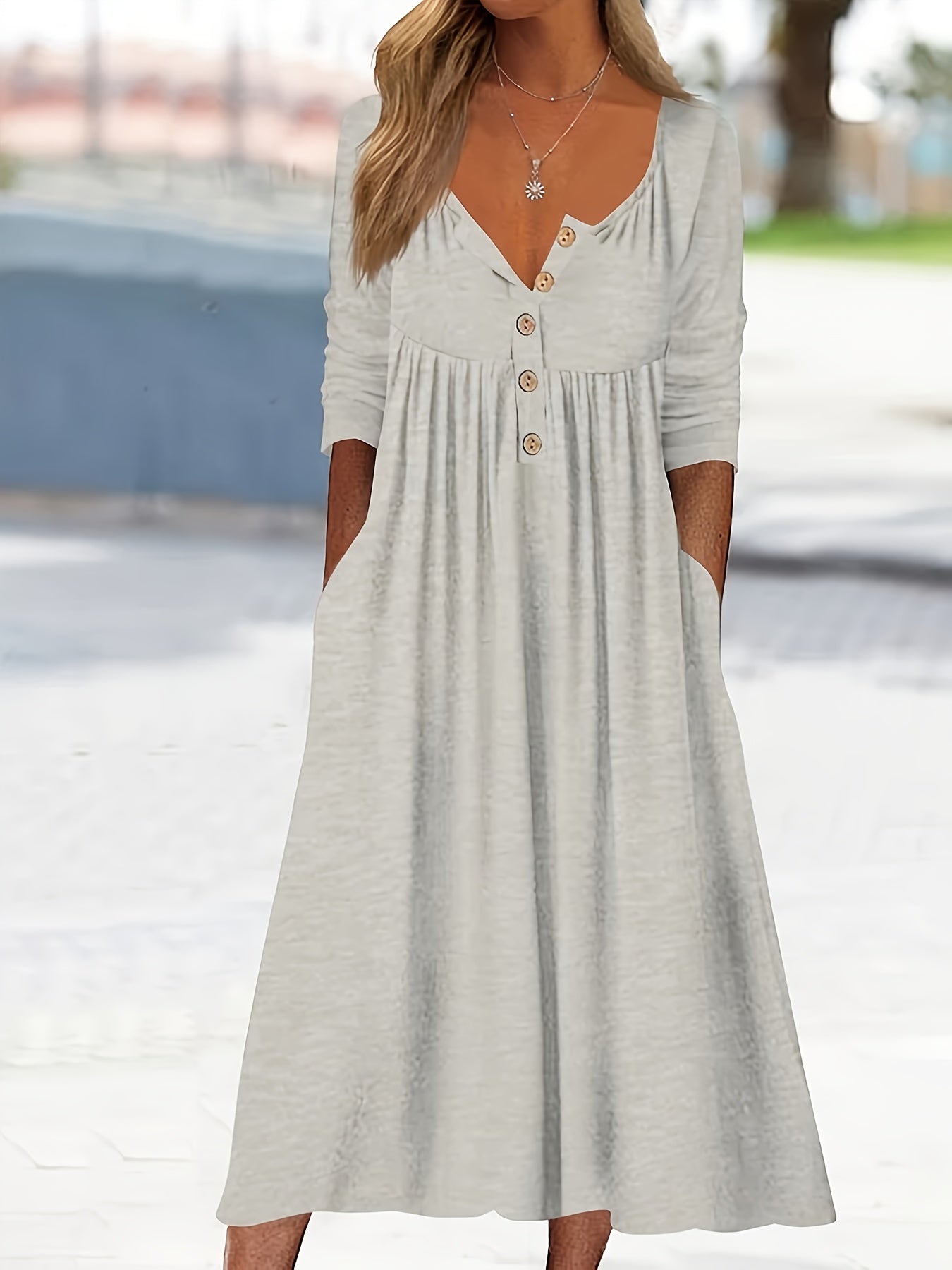 Vestido midi com botões frontais, manga comprida, bolsos e bainha com babados.