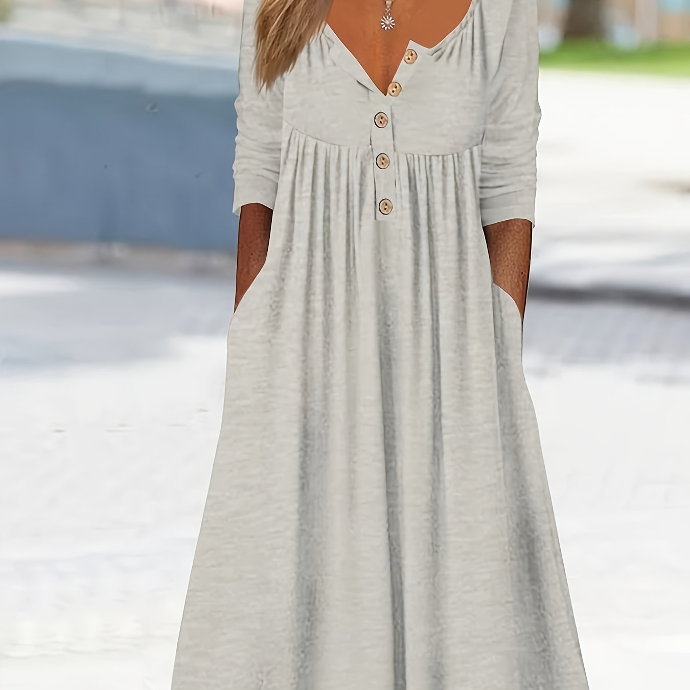 Vestido midi com botões frontais, manga comprida, bolsos e bainha com babados.